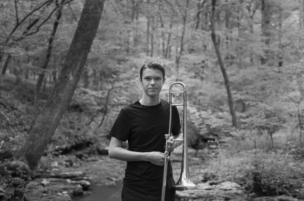 A lad in the woods with his trombone. Black and White photography.